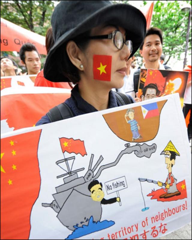 Một phụ nữ Việt Nam mang theo áp phích với khẩu hiệu: “Trung Quốc, ngừng vi phạm lãnh thổ các nước láng giềng”.
