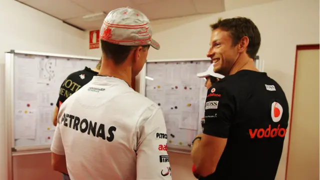 Pembalap Mercedez Michael Schumacher dan pembalap McLaren meluangkan waktu untuk membaca pengumuman sebelum ikut parade pembalap.