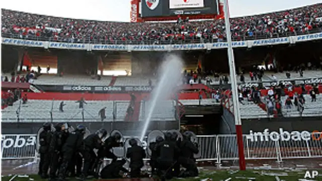 La policía lanza agua a presión contra la barra brava de River Plate para evitar que invadan el estadio.