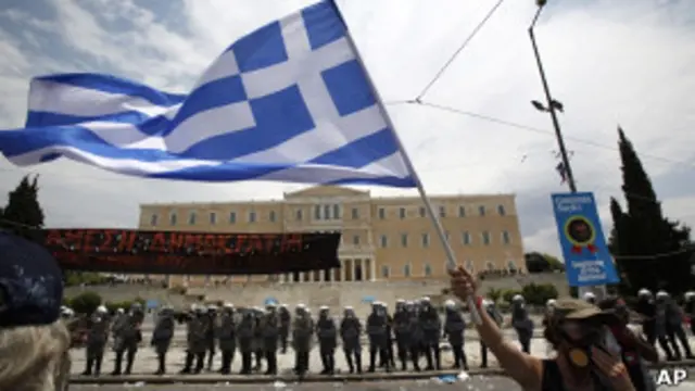Mulher com máscara contra gás protesta na Praça Sintagma, em Atenas. Foto: Reuters