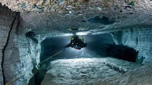 Водолаз плывет между валунов