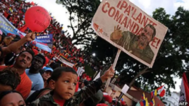 Criança segura cartaz com rosto do presidente Hugo Chávez em manifestação de apoio em Caracas (AFP)