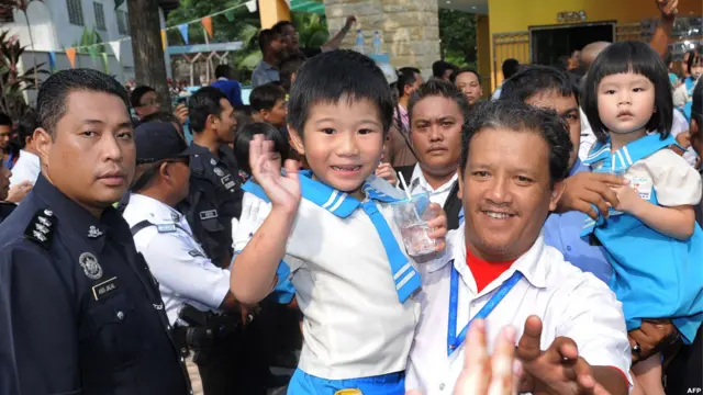 Polisi menggendong murid yang baru dibebaskan