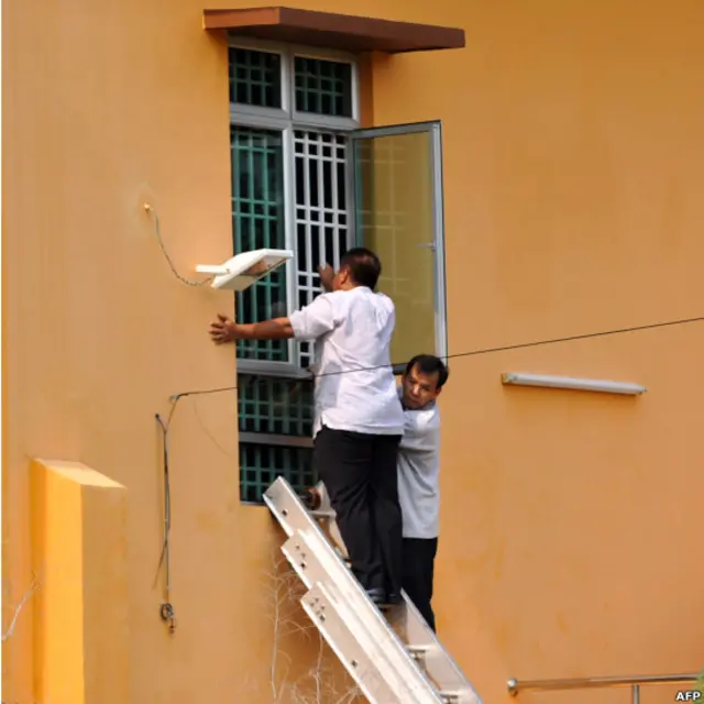 Polisi memanjat tangga untuk bisa berkomunikasi dengan penyandera.