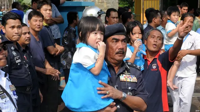 Polisi menggendong murid yang baru dibebaskan