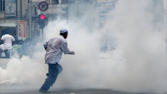 Demonstran menghadapi asap peluru gas air mata di Kuala Lumpur