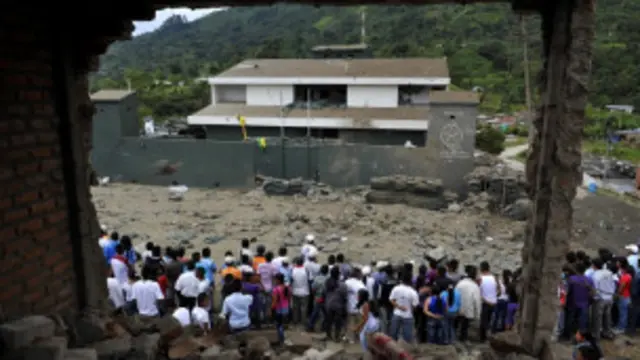 Warga Toribio menyaksikan kantor polisi kota itu yang rusak diserang pemberontak.