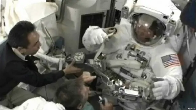 El astronauta Satoshi Furukawa junto al comandante del Atlantis, Chris Ferguson, ayudando al ingeniero Mike Fossum