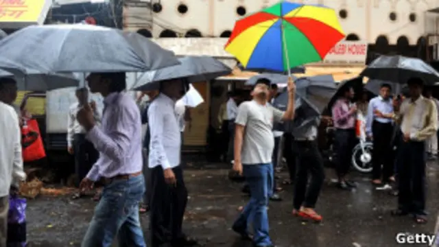 Прохожие в Мумбаи с зонтами в руках