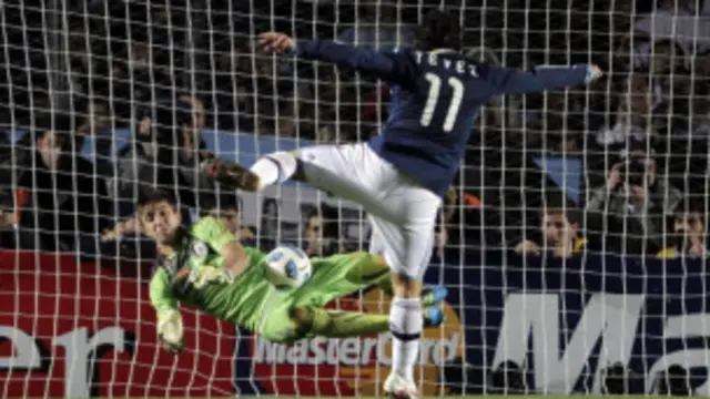 Penjaga gawang Uruguay, Fernando Muslera, gagalkan tendangan penalti Carlos Tevez.