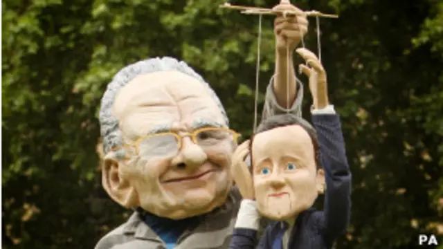 Человек в маске Мердока держит марионетку Кэмерона