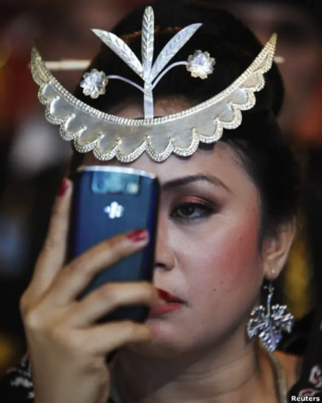 Pengantin perempuan memotret dirinya sendiri dengan telepon genggam