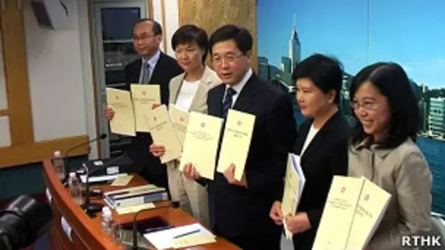 香港政制及內地事務局局長林瑞麟（中）向媒體展示立法會替補機制諮詢文件（香港電台圖片22/7/2011）