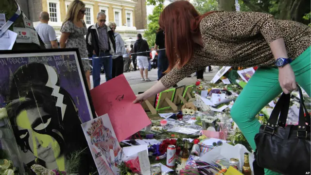 Penggemar Amy Winehouse meletakkan karangan bunga