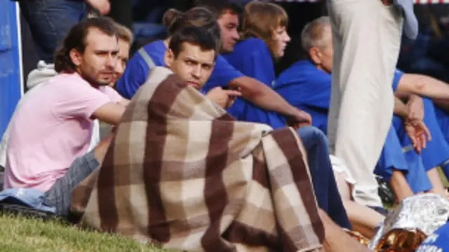 Para korban yang berhasil diselamatkan masih menunggu evakuasi di tepian Sungai Moskow