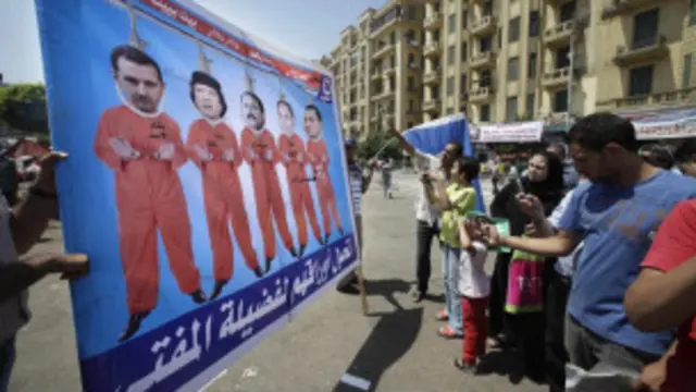 Manifestante egípcio exibe cartaz retratando o líder egípcio deposto, Hosni Mubarak, seu filho, Gamal, o líder deposto da Tunísia, Ali Abudalah Saleh, o líder deposto da Líbia, Muamar Khadafi e o presidente da Síria, Bashar al Assad, na Praça Tahrir (AP) 