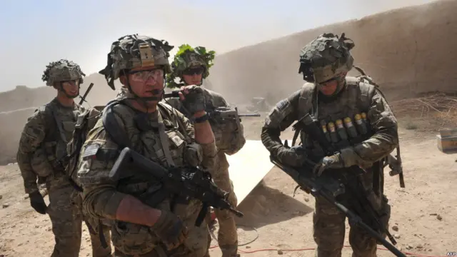 Pasukan AS dari kesatuan Charlie Company berpatroli di desa Kandalay sesudah serangan Taliban.