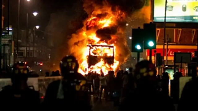 Sebuah bus terbakar dalam kerusuhan yang terjadi di Tottenham, London.
