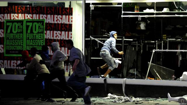 Участники беспорядков грабят магазин одежды