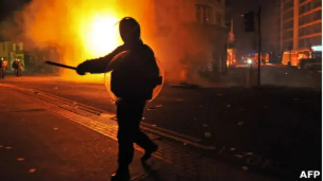 Policial em frente a um edifício em chamas em Croydon, no sul de Londres. 