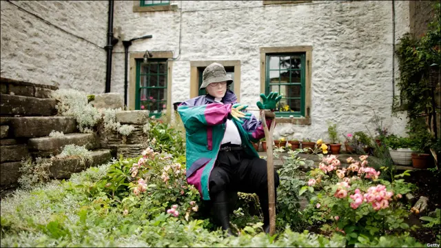 一名“村民”在用铁锹修整自家的花园。