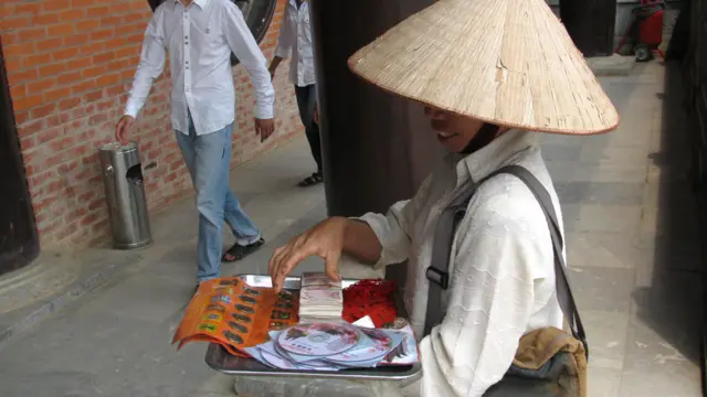 Đôi ba phụ nữ địa phương vào sân chùa bán đồ cúng tế, hương hoa để kiếm sống nhưng không thấy mấy ai mua.