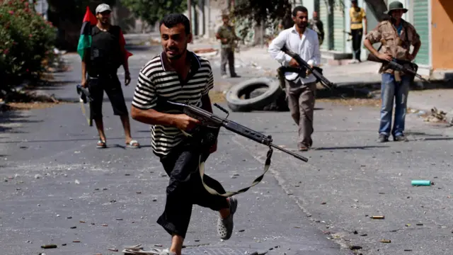 Pemberontak Libia bergerak ke arah ibu kota Tripoli. Salah satunya terlihat berusaha menghindar dari tembakan di Zawiya, 40 km barat Tripoli. 