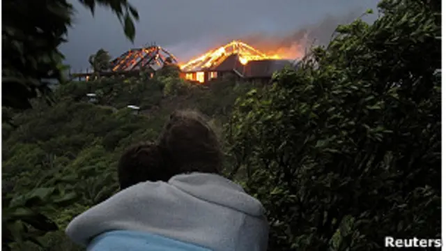 Два человека наблюдают за пожаром на вилле Брэнсона