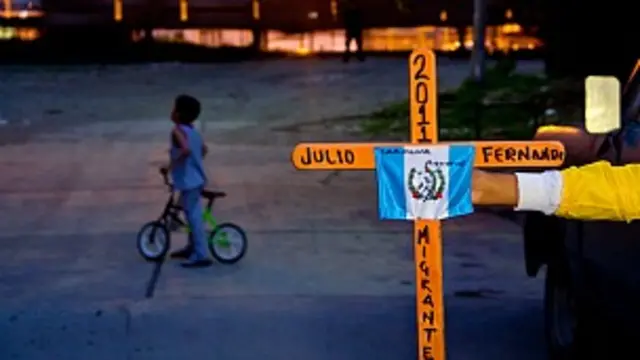 Migrante centroamericano sostiene una cruz en México