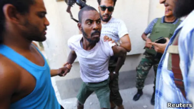 Повстанцы охраняют задержанного мужчину в Триполи