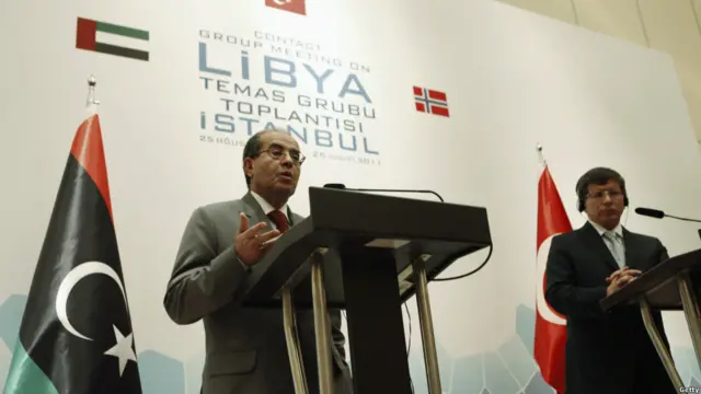 Đại diện Hội đồng Chuyển tiếp Quốc gia (NTC) của Libya mở cuộc họp báo cùng Ngoại trưởng Thổ Nhĩ Kỳ Ahmet Davutoglu (phải) tại Istanbul vào hôm 26/8/2011, tìm cách vận động quốc tế bỏ cấm vận áp dụng thời ông Gaddafi.