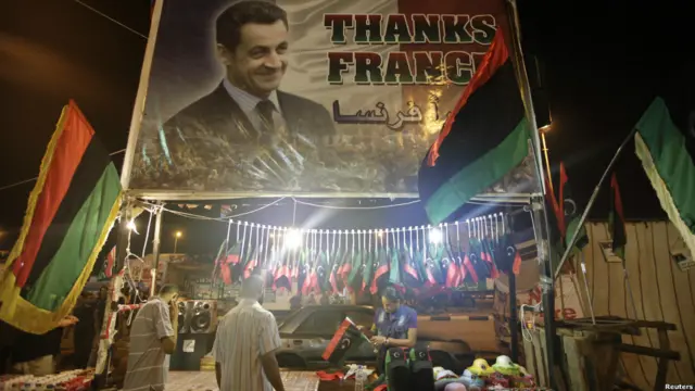 Cũng tại Quảng trường Tahrir ở Benghazi, hàng lưu niệm được bán, gồm cả cờ Libya thuộc chế độ mới, dưới tấm biển lớn ngỏ lời cảm ơn Tổng thống Pháp Nicholas Sarkozy. Paris là một trong những điểm dừng chân chính của lãnh đạo phe nổi dậy Libya để vận động dỡ bỏ lệnh phong tỏa tài sản quốc tế.