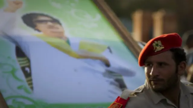  جندي أمام جدارية للقذافي في سرت