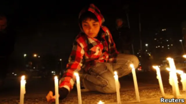 Chilena acende vela em frente à sede da TV Nacional