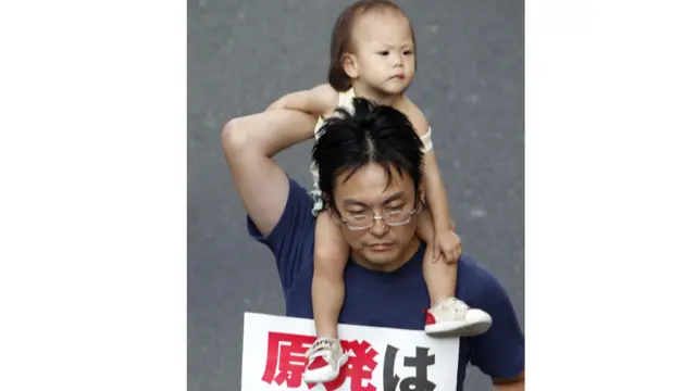 Peserta unjuk rasa di Jepang membawa anaknya