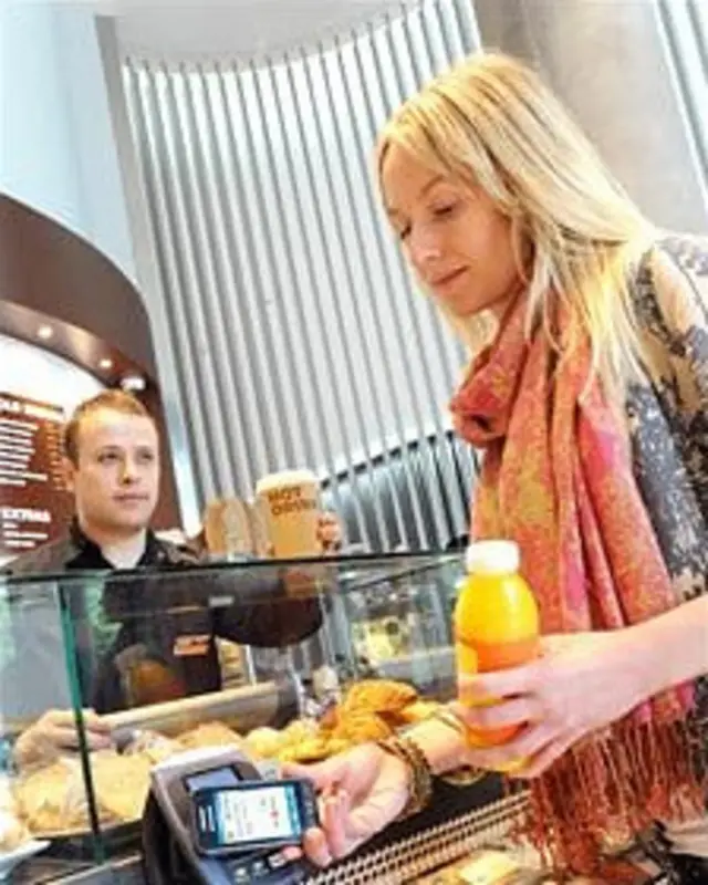 Un consumidor pega su celular a un lector inalámbrico