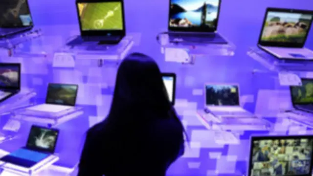 Una mujer frente a varias computadoras