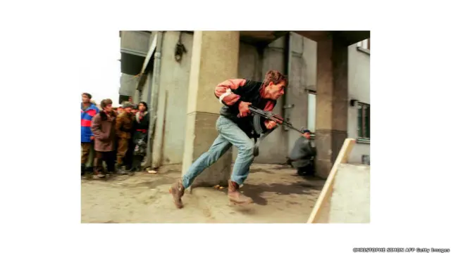 Ушбу сурат 1989 йил 24 декабрида Руминия пойтахти Бухарестда олинган. Антикоммунист ноҳарбий жангчи мамлакатни 24 йил бошқарган Николай Чаушескуга содиқ махфий полиция жангчиларини қувиб бормоқда.