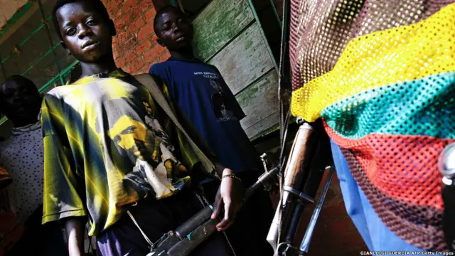 یک کودک سرباز در کنار یک سرباز حافظ صلح سازمان ملل، دسامبر ۲۰۰۴ در روستایی در کنگو.