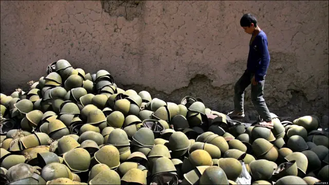 2005-жыл. Афган жергесине Советтик армия таштап кеткен каскаларды тепселеген бала.