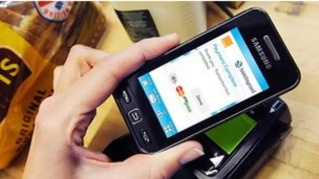 Un consumidor pega su celular a un lector inalámbrico