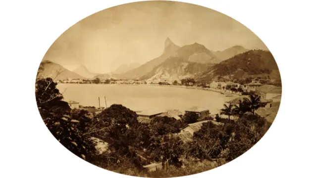 Este é um dos primeiros registros do Corcovado, feito por volta de 1865. No primeiro plano se vê o casario da praia de Botafogo, antes dos sucessivos aterros que alargariam a orla. A importância do morro como marco geográfico da cidade já se via antes da fotografia, em desenhos e aquarelas feitos por artistas de expedições, diz Sergio Burgi. (Foto:Georges Leuzinger/ IMS)