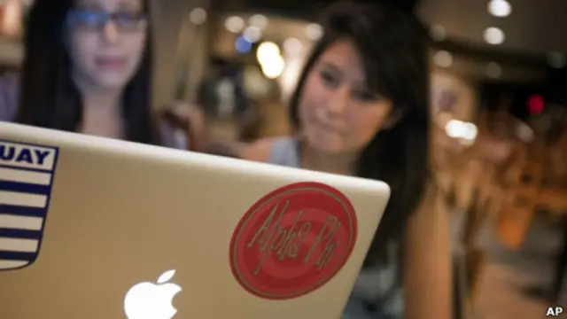 Dos jóvenes ven la pantalla de un laptop