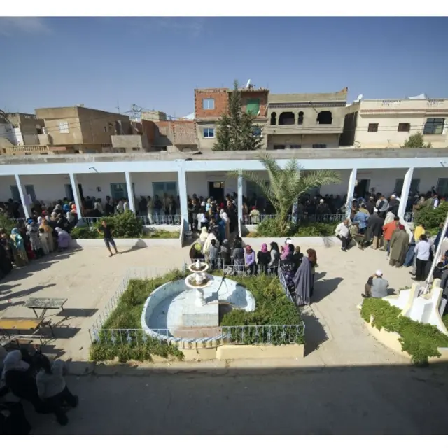 突尼斯工人区的投票站外排队的选民