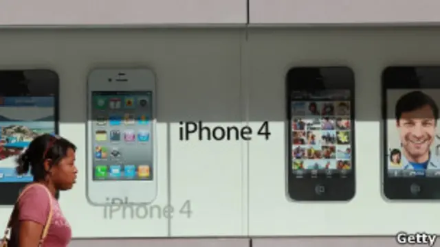 Una persona pasa por un cartel de iPhone 4S