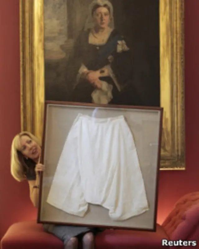 сотрудница аукционного дома с выставленным лотом