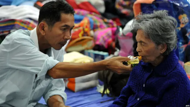Seorang pria membantu ibunya makan