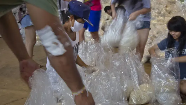 Pekerja sukarela membungkus beras