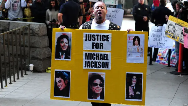 控方称，穆里在没有安全的保证下使用了危险剂量的镇静剂，在杰克逊昏迷后，穆里又放弃了抢救措施，最终导致杰克逊死亡。一名杰克逊的歌迷在法庭外为他讨公道。 