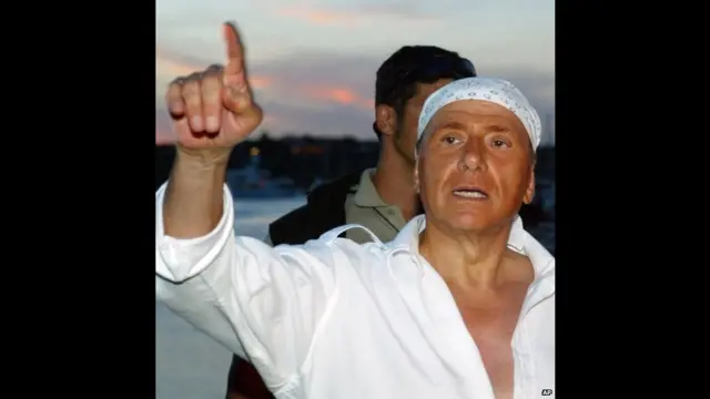 برلسکونی ڈھلتی عمر سے مقابلہ کرتے آئے ہیں جیسا کہ 2004 کی اس تصویر میں انہوں نے نئے لگوائے گئے بالوں کو چھپانے کے لیے بندانہ پہنا ہوا ہے۔ ان کے اس اقدام پر اٹلی اور بیرونی ممالک میں ان کا بہت مذاق اڑایا گیا۔ وہ اس سال بہت کم ووٹوں سے انتخاب بھی ہار گئے۔